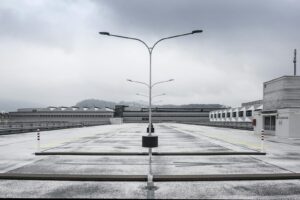 Un parking sur le toit désert avec des lampadaires par une journée d'hiver nuageuse.