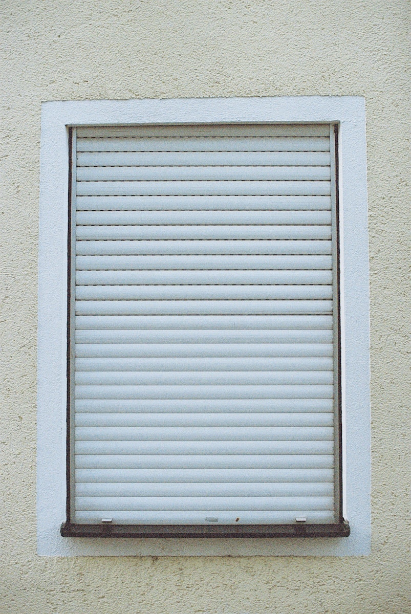 stores blancs sur mur en béton blanc