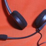 Casque audio noir avec micro réglable sur fond rouge