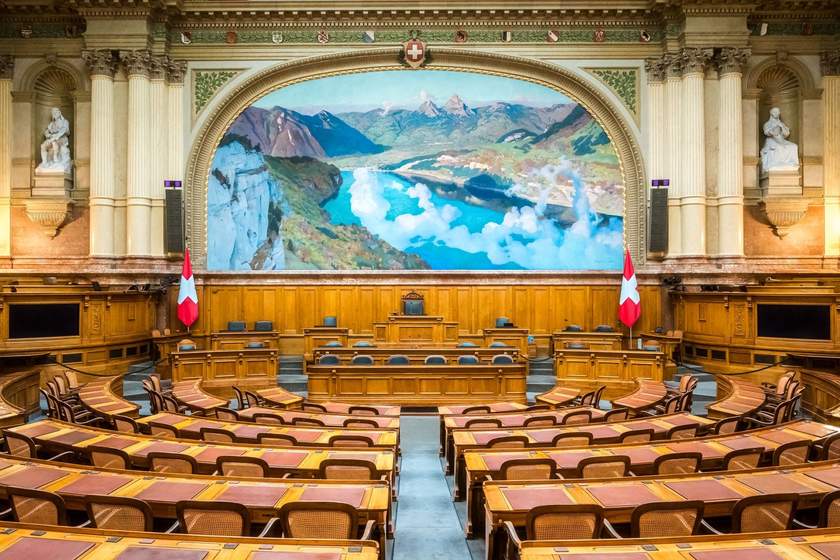 Salle de réunion avec amphithéâtre, bureau central, drapeaux, tableau mural paysager